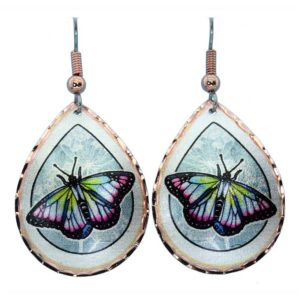 Copper Butterfly Earrings - How We Make Copper Jewelry Copper butterfly earrings resting on a silvery blue flower background, illustrating the beautiful results of how we make copper jewelry.
