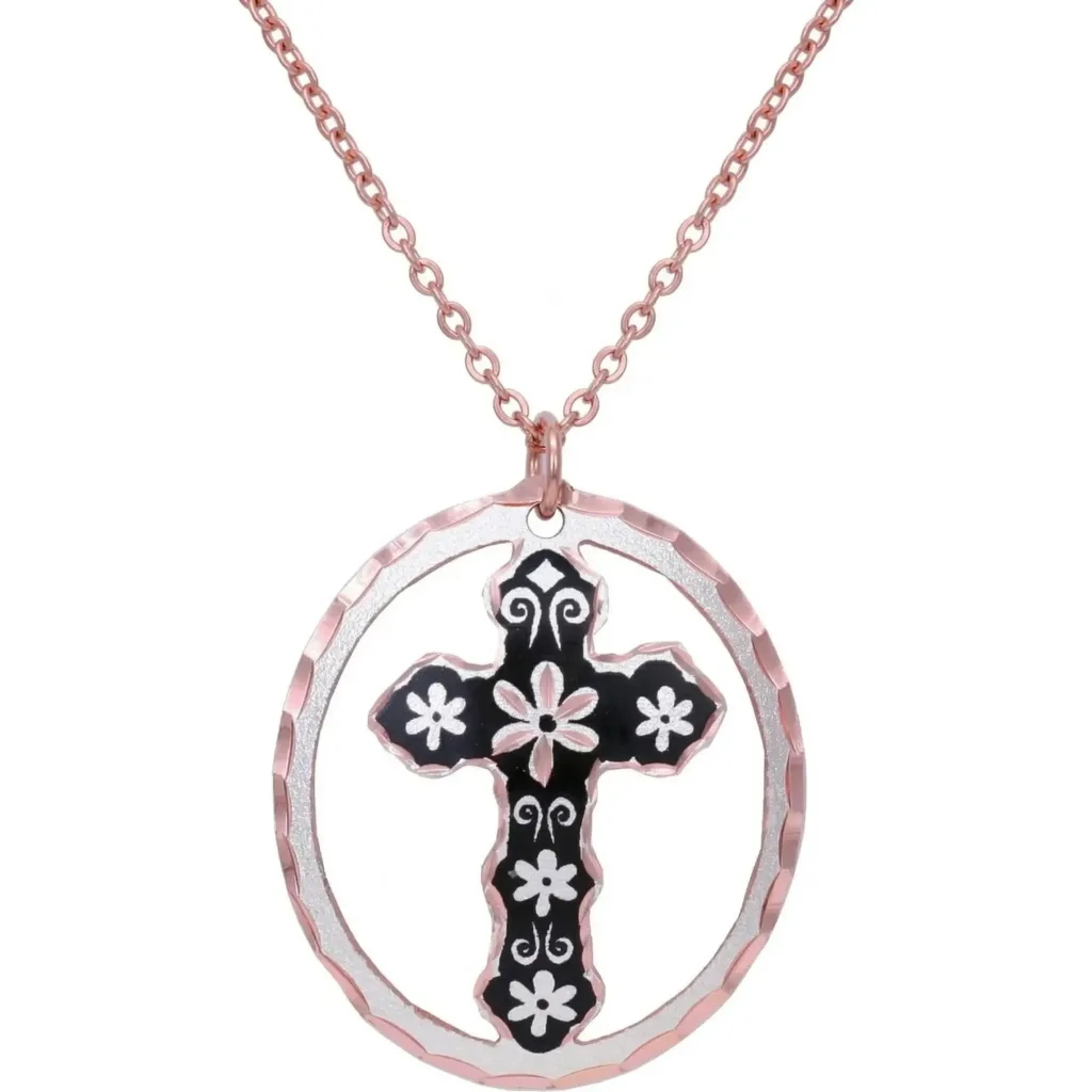A captivating handcrafted necklace featuring a beautiful cut-out floral cross design. Crafted from silver-plated copper, the artisan pendant highlights intricate details with elegant black accents and brilliant diamond cuts for a luxurious sparkle.